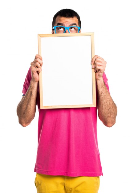 Foto homem com roupas coloridas segurando um cartaz vazio