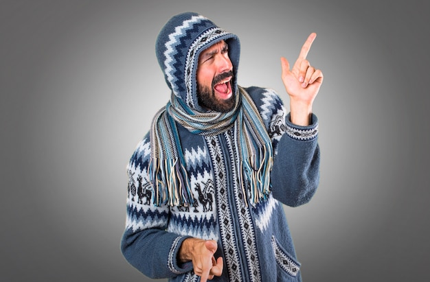 Homem com roupas de inverno dançando em fundo cinza