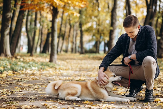 Homem com seu cachorro andando no parque outono