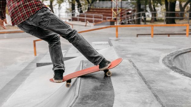 Homem com skate do lado de fora no parque