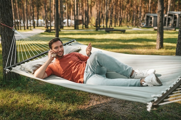 Homem com smartphone relaxando na rede