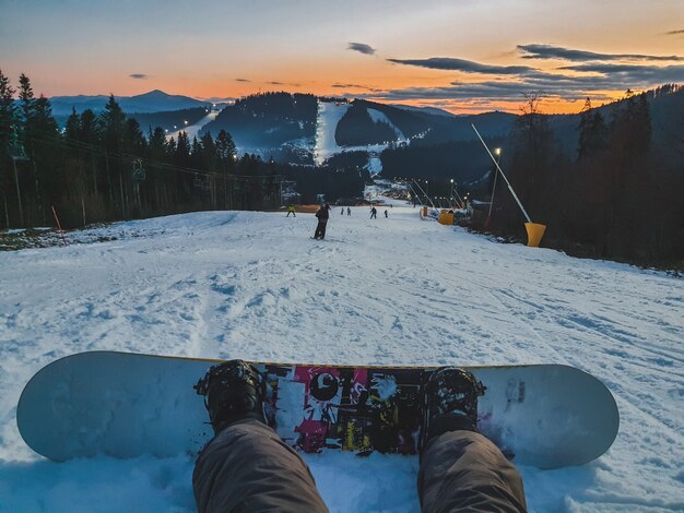 Homem com snowboard sentado na pista de esqui copie o espaço