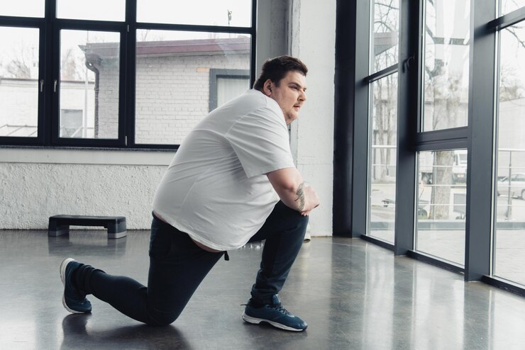 Foto homem com sobrepeso esticando as pernas no centro esportivo com espaço de cópia