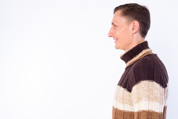 Foto homem com suéter de gola alta pronto para o inverno isolado contra uma parede branca