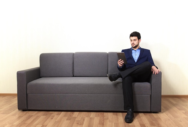 Homem com tablet PC sentado no sofá
