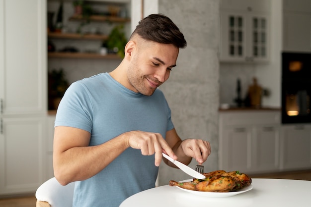 Homem com transtorno alimentar tentando comer frango