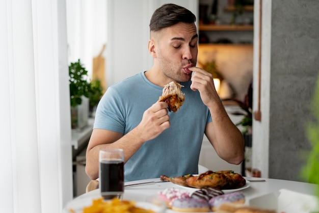 Homem com transtorno alimentar tentando comer frango