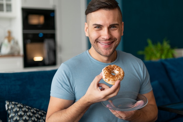 Homem com transtorno alimentar tentando comer rosquinha