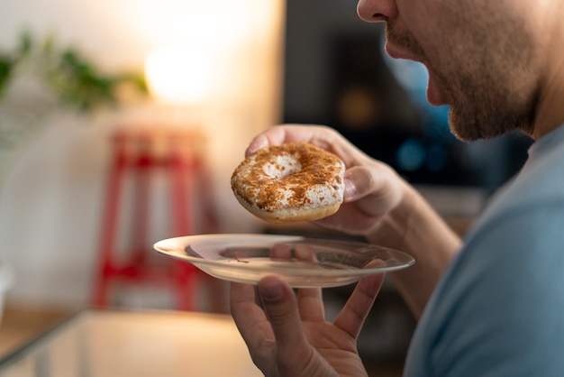 Homem com transtorno alimentar tentando comer rosquinha