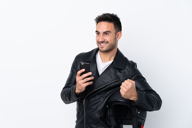 Homem com um capacete de moto com telefone em posição de vitória