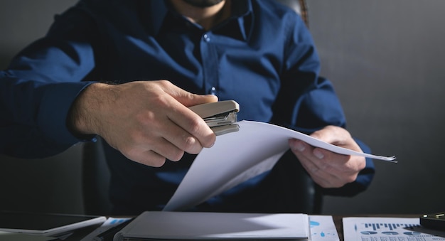 Homem com um grampeador conecta os documentos.