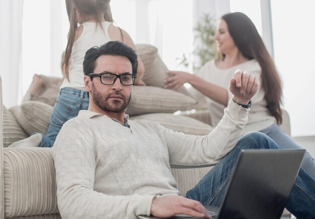 Homem com um laptop sentado na sala de estar pessoas e tecnologia