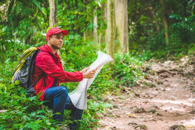 Foto homem com um mapa na floresta