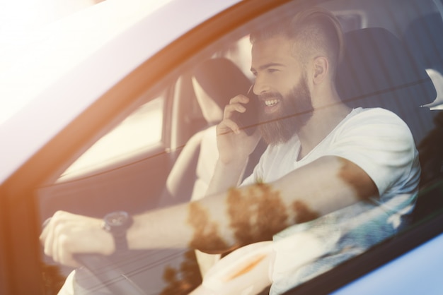 Homem com uma barba senta-se ao volante de um veículo elétrico