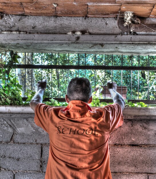 Homem com uma camisa da escola segurando barras de celular