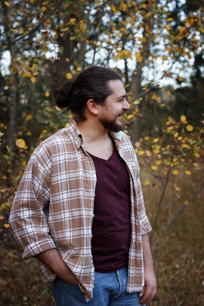 homem com uma camisa xadrez sorrindo em uma caminhada de outono