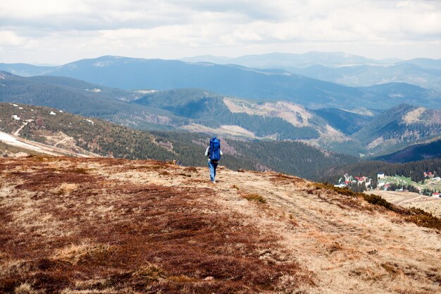 Homem com uma grande mochila na montanha, viajante de montanha com uma mochila grande