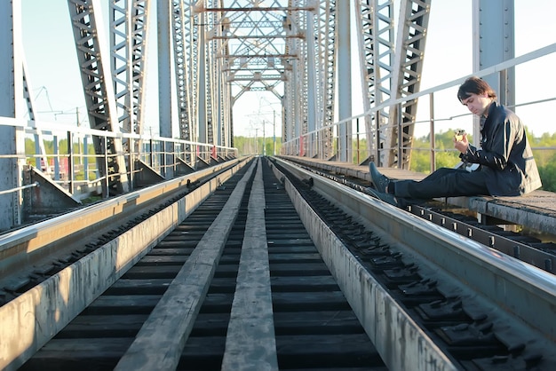 Homem com uma guitarra em uma ferrovia