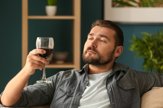 Homem com uma taça de vinho relaxando em casa