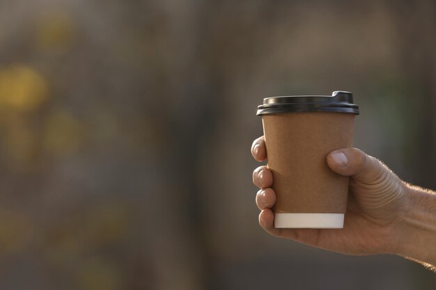 Homem com uma xícara de café para viagem ao ar livre fechada Espaço para texto