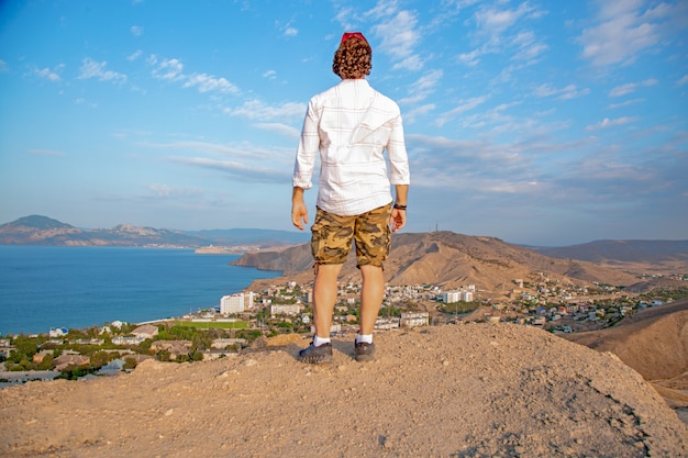 Homem com vista para uma vista panorâmica de uma bela costa da colina