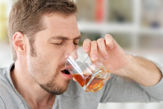 Homem com whisky no copo, problema de alcoolismo, conceito de abuso de álcool