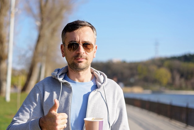 Homem, com, xícara café, e, polegar cima