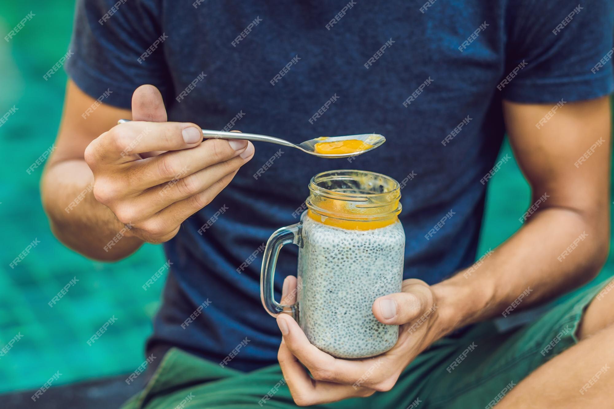 Pai e filho comem sobremesa com sementes de chia e mangas à beira da  piscina pela manhã. alimentação saudável, comida vegetariana, dieta e  conceito de pessoas.