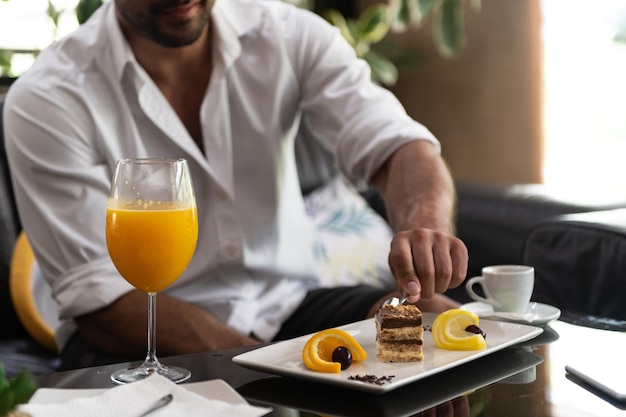 Homem comendo bolo em um bar do lobby do hotel