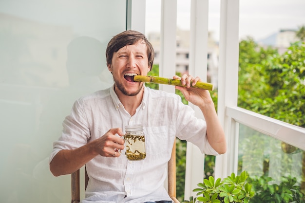 Homem comendo cana de açúcar e bebendo chá