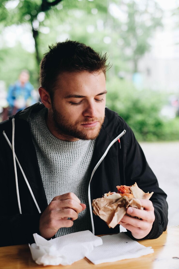 Foto homem comendo comida na mesa