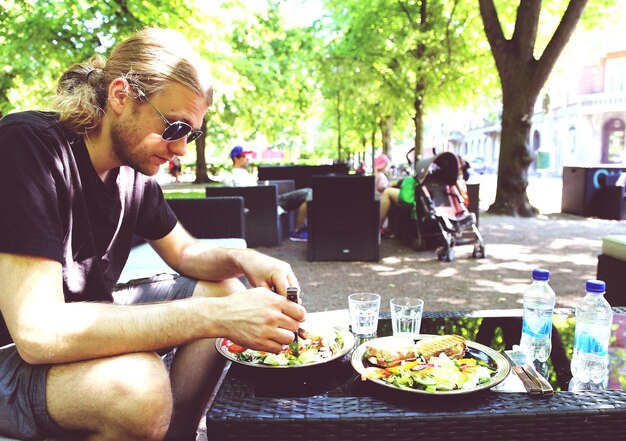 Foto homem comendo comida no restaurante