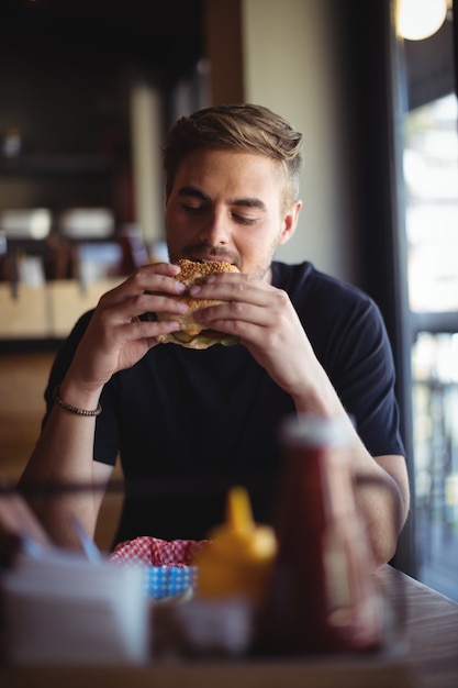 Homem comendo hambúrguer