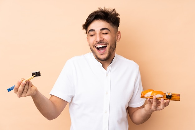 homem comendo sushi isolado em bege