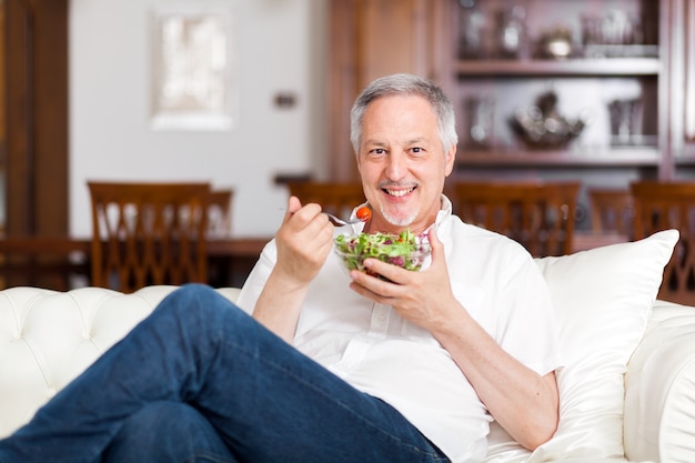 Foto homem comendo uma salada