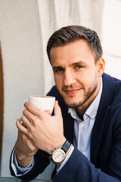 Homem como café Homem bonito com uma xícara de café no café Estilo de vida matinal do homem