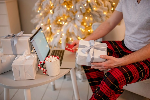 Homem comprando presentes de natal online no laptop