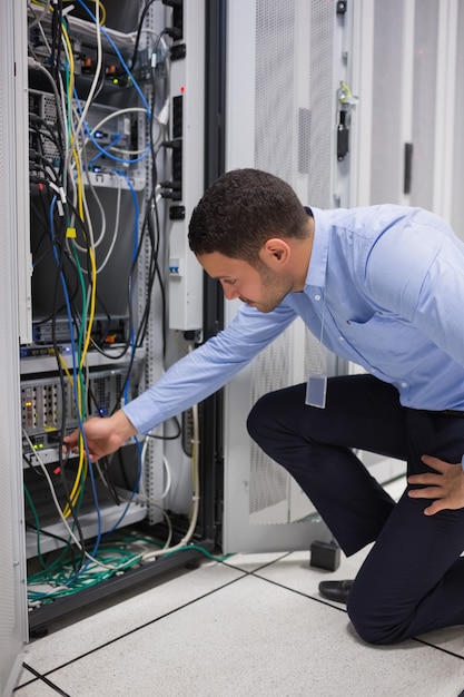 Homem conectando um cabo no servidor