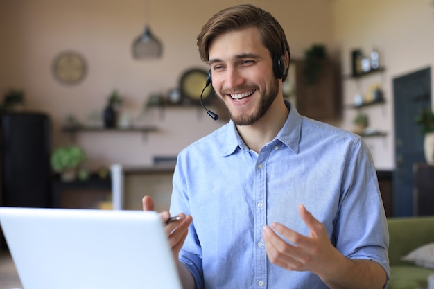 Homem confiante usando fone de ouvido, falando e assistindo o treinamento do webinar de negócios, ouvindo a palestra.