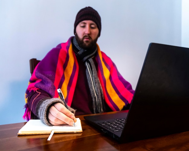 homem congela enquanto trabalha no escritório frio em casa frio no trabalho crise de energia 2022 inverno 2022