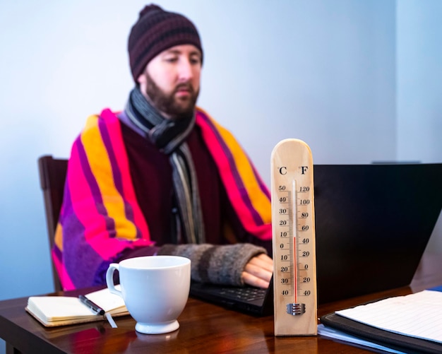 Foto homem congela enquanto trabalha no escritório frio em casa frio no trabalho crise de energia 2022 inverno 2022