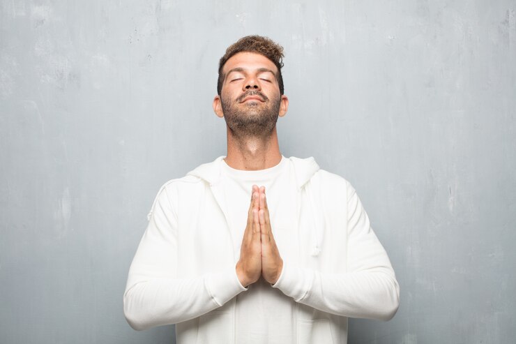 Foto homem considerável novo que praying em uma maneira santly, implorando