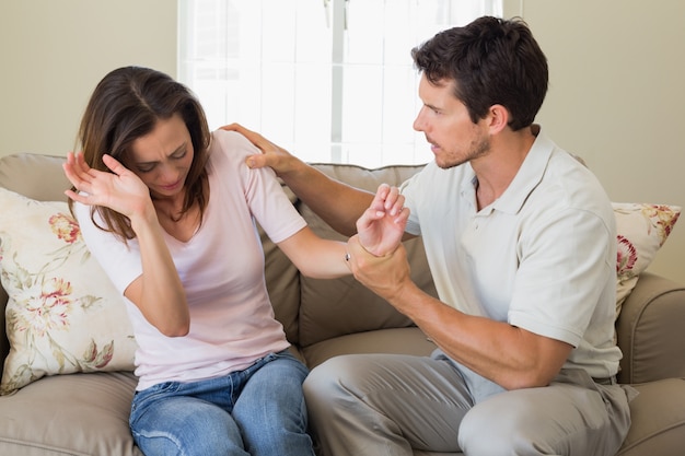 Homem consolando uma mulher triste na sala de estar