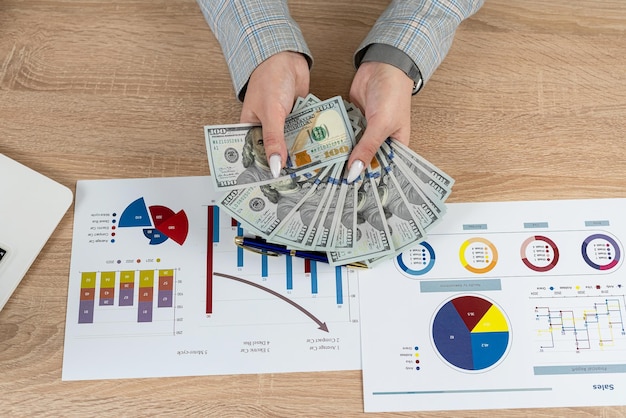 Homem conta dólar gráfico de negócios e gráfico na mesa de escritório estratégia de ganhar dinheiro com o investimento