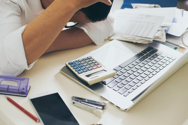 Homem contando usando calculadora e estresse em problema com despesas