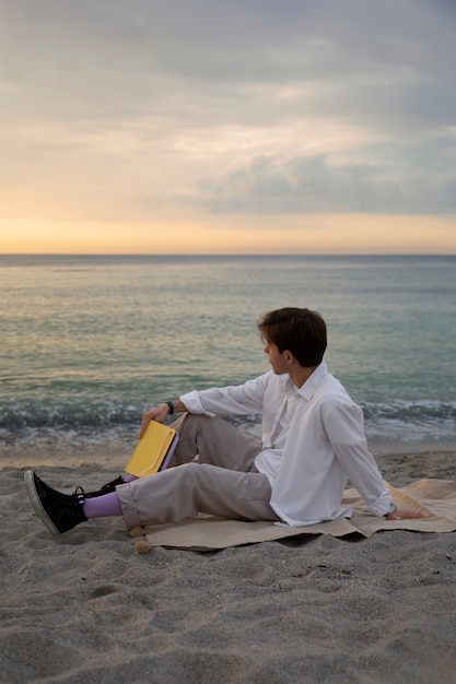 Foto homem contemplativo de tiro completo à beira-mar