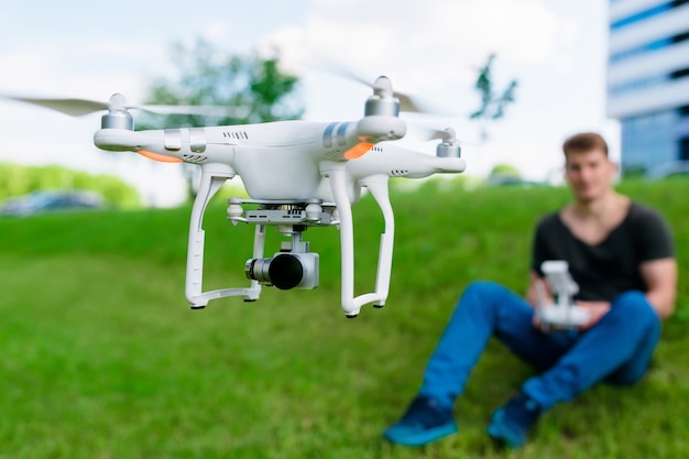 Homem controla drone na rua