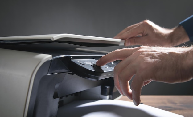 Homem copiando e digitalizando documentos no escritório.