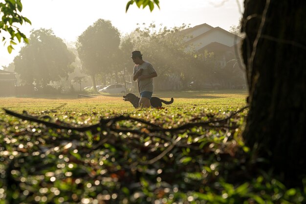 Homem correndo com seu cachorro de estimação no campo