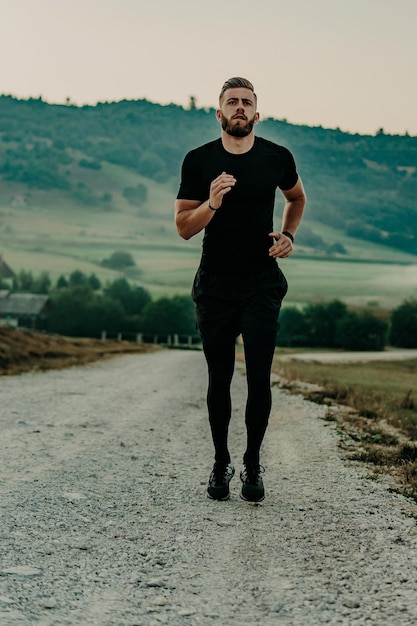 Homem correndo / correndo na estrada nas montanhas. Ajuste o corredor de fitness masculino durante treino ao ar livre. Homem caucasiano novo.